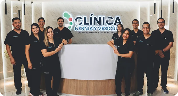 Equipo médico del Instituto de Hernias frente al letrero de la clínica